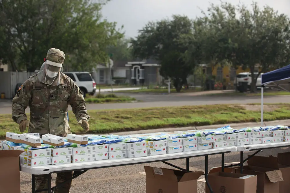 U.S. Army Spc. Jesus Rodriguez of the 3rd Battalion, 141st Infantry, Headquarters and Headquarters Company, set up food packages at the Alton Recreation Center in Alton, Texas, April 24, 2020. Texas Military Department service members team up with volunteers to provide assistance to local food banks across Texas supporting support local families in need during the COVID-19 pandemic. (Leyda Ocasio-Kanzler)