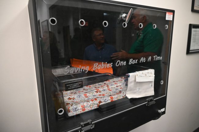 The box inside the station. The reflexion against the plexiglass is that of Palm Coast Mayor Mike Norris, one of four members of the City Council who attended the blessing. Dave Sullivan, Charles Gambaro and Theresa Pontieri were also in attendance. (© FlaglerLive)