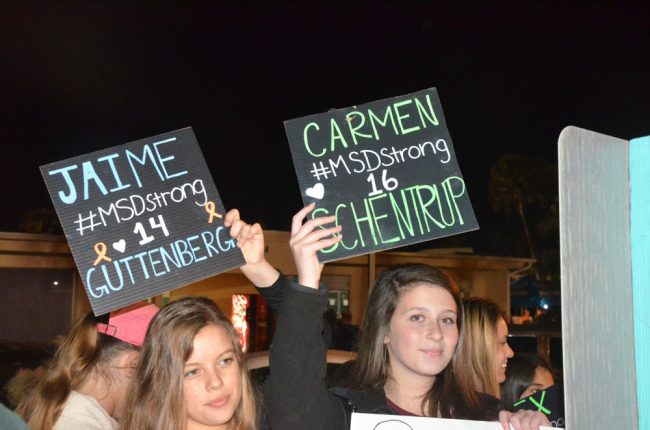 High school students at Veterans Park in March 2018, holding up names of two of the 17 victims of the Parkland massacre. (© FlaglerLive)