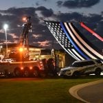The "thin blue line" flag hanging from John's Towing cranes near the Operations Center Thursday evening. (© FlaglerLive)