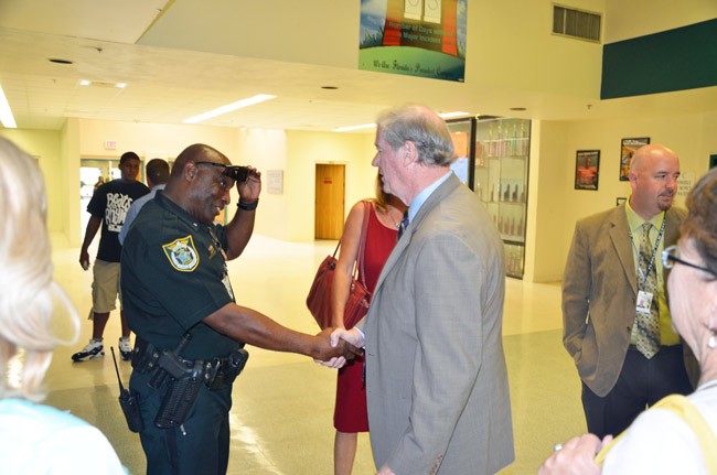 Then Sen. John Thrasher--now president of Florida State University--shaking hands with Calvin Grant, the school resource deputy, at Flagler Palm Coast High School during a visit in 2012, with Jacob Oliva, now the superintendent, behind Thrasher. (© FlaglerLive)