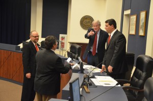 Sen. John Thrasher and Rep. Travis Hutson, on the dais, speak with Ken Mattison, CEO of Florida Hospital Flagler (in the red tie), and Andy Dance, chairman of the Flagler County School Board, just before the legislative delegation meeting. Click on the image for larger view. (© FlaglerLive)