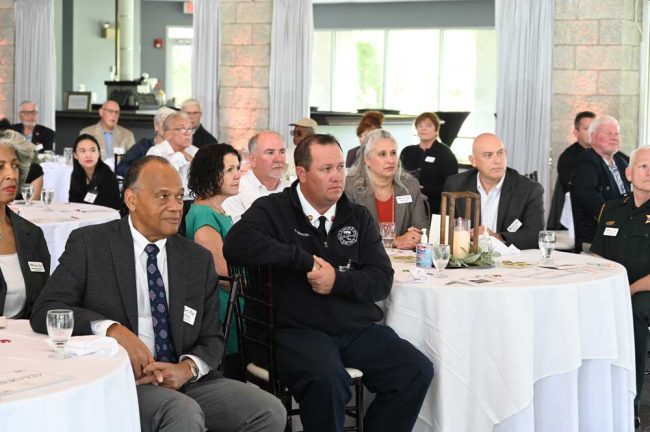 Tough Crowd. The table to the right, front and center before Aronberg, included, from left, County Judge Andrea Totten, Sheriff Rick Staly, Palm Coast Fire Chief Kyle Berryhill, County Judge Melissa Distler, John Distler, and Chief Marek Strobridge. Further left at the neighboring table, Greg Davis, president of Flagler Tiger Bay. (© FlaglerLive)