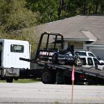 A tow truck took the motorcycle after the crash at U.S. 1 and Karat Path at the edge of Seminole Woods in mid-morning Sunday. Both riders were killed. (© FlaglerLive)