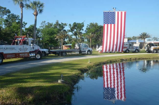 Some 15 tow trucks were arrayed in a semi-circle around the pond in front of the old city hall. Click on the image for larger view. (© FlaglerLive)