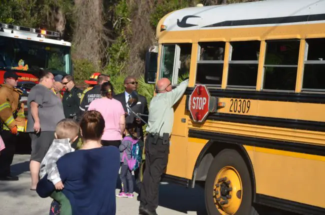 Transportation Director Andy West speaking to someone in the bus, with Earl Johnson, the superintendent's deputy, to West's left, moments before the children on the bus were  directed to another bus. Click on the image for larger view. (© FlaglerLive)