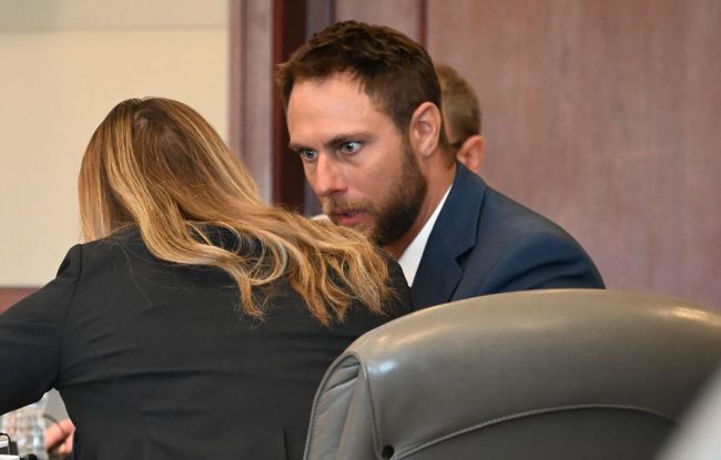 Travis Smith conferring with one of his lawyers. (© FlaglerLive)
