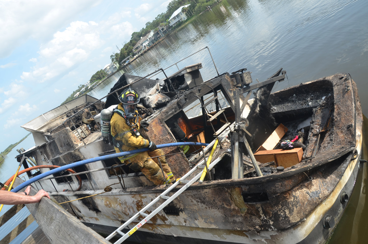The trawler had started its journey in DeLand. It began smoking near the Flagler Beach bridge, where its pilot docked it and got off as the flames went out of control. Two hours later the boat was totaled. Click on the image for larger view. (© FlaglerLive)