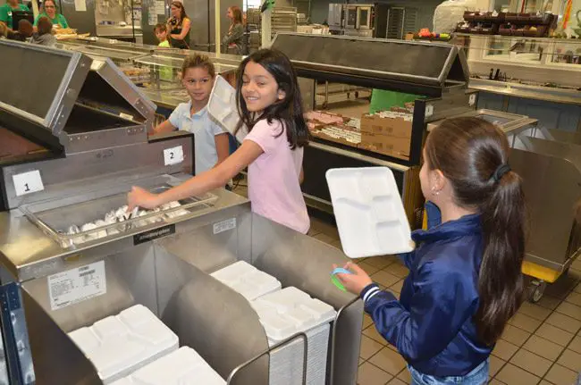 2nd graders at Old Kings boycotted the use of plastic trays on the way to convincing the administration to adopt more eco-friendly, biodegradable paperboard trays that don;t harm oceans, as plastics do. Today marked the first day of the trays' use county-wide. (© FlaglerLive)