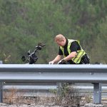 A Florida Highway Patrol trooper processing the victim's motorcycle on I-95 this morning. The crash took place just north of the weigh scales, south of the intersection with Palm Coast Parkway. (© FlaglerLive)