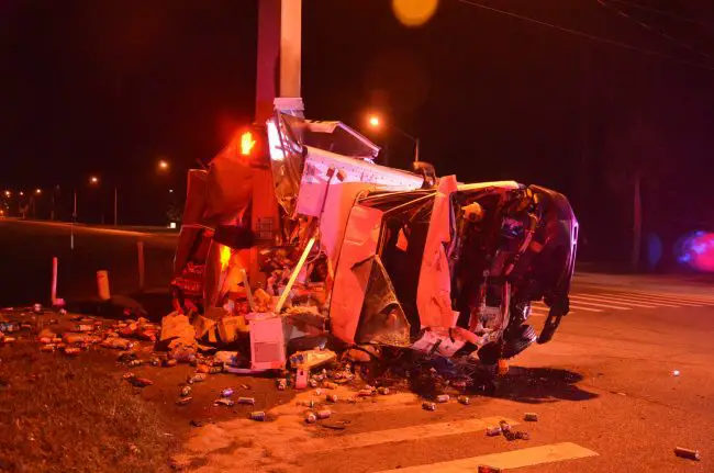 The Canteen junk-food delivery truck was criushed against a concrete light pole at Palm Coast Parkway and Belle Terre Parkway before dawn this morning. Click on the image for larger view. (© FlaglerLive)