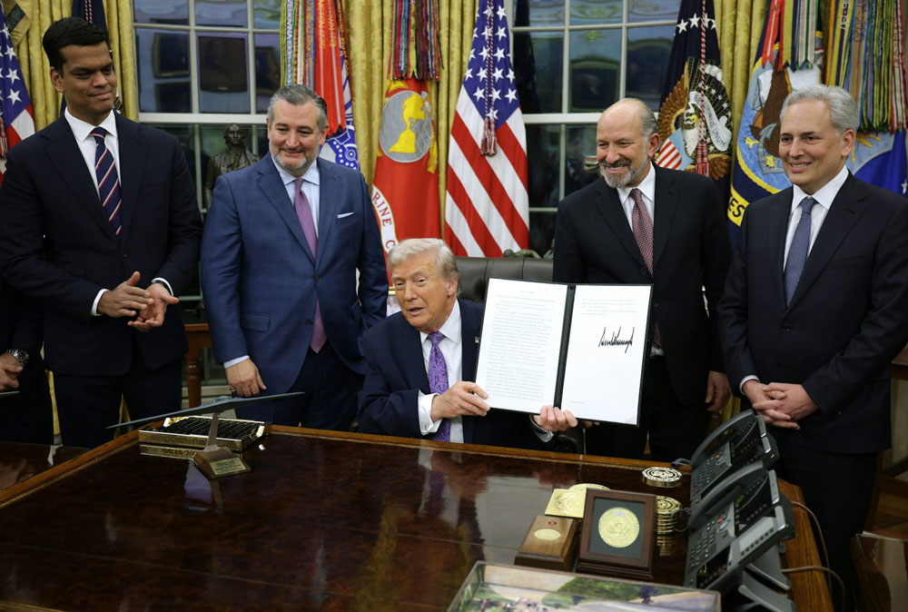 President Donald Trump displays his executive order countering state laws regulating AI.