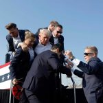 U.S. Secret Service agents help former President Donald Trump offstage during a rally on July 13, 2024, in Butler, Pa.