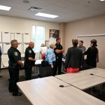 Members of the Flagler County School Board in a huddle with Flagler County Sheriff's deputies before this evening's meeting as they were being cautioned--and directed--on following deputies' directions in case the meeting turned chaotic. It was an unprecedented caution. (© FlaglerLive)