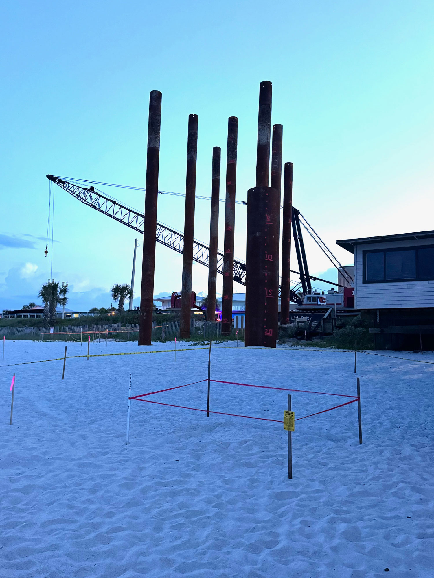 The loggerhead turtle nest in the path of the Flagler Beach pier construction trestle, in a picture taken Wednesday at dawn. The earlier nest is visible against the dune line, to the left. The Flagler Turtle Patrol builds a 10-by-10 enclosure, and in these two cases also built 20-by-20 enclosures to delineate where pilings may not cross. (© Rick Belhumeur for FlaglerLive)