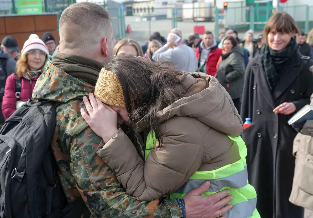 A woman hugs a Polish volunteer before he crosses the border to go and fight against Russian forces.