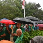 A canopy of umbrellas opened as the skies did during the blessing of the new Safe Haven Baby Box outside Palm Coast Fire Station 25 this afternoon. (© FlaglerLive)