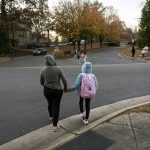 An undocumented Honduran immigrant walks her child to a school bus stop in November 2025 at an unspecified location in the U.S.