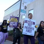 Striking Kaiser Permanente workers hold signs as they march on Oct. 6, 2023, in Vallejo, Calif.