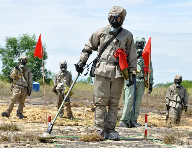 A Vietnamese soldier demonstrates unexploded-ordnance detection and clearance in Danang in June 2011. Since 1975, The New Yorker reporter, more than 40,000 Vietnamese have been killed by unexploded ordnance many of them in Quang Tri, a province that was also 'sprayed with more than seven hundred thousand gallons of herbicide, mainly Agent Orange.' (USAID)