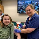 Registered Nurse Shanna Brayman gives a flu shot to her daughter Faith Buckley, a junior at Flagler Palm Coast High School. (Department of Health)