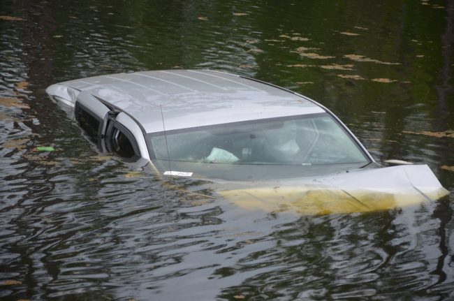 One of the two vehicles, with a mom and two children on board, ended up in the pond by an access road near Palm Coast Parkway. Click on the image for larger view. (c FlaglerLive)