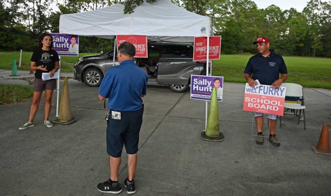 Courtney VandeBunte and Will Furry battling for a voter in the waning hours of Election Day today at Palm Coast Bible Church. They'll be battling until the November election, as they are now in a runoff. (© FlaglerLive)