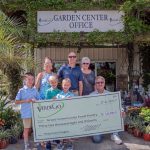 TJ McNitt, president and owner of Verdego, with his family and with Pastor Charles Silano, right, with the ceremonial $32,000 check. (Verdego)