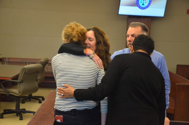 Assistant State Attorney Melissa Clark, hugs the victim after the verdict, with Sheriff's Detective Dennis Lashbrook, who investigated the case, and the State Attorney's victim's advocate. (© FlaglerLive)