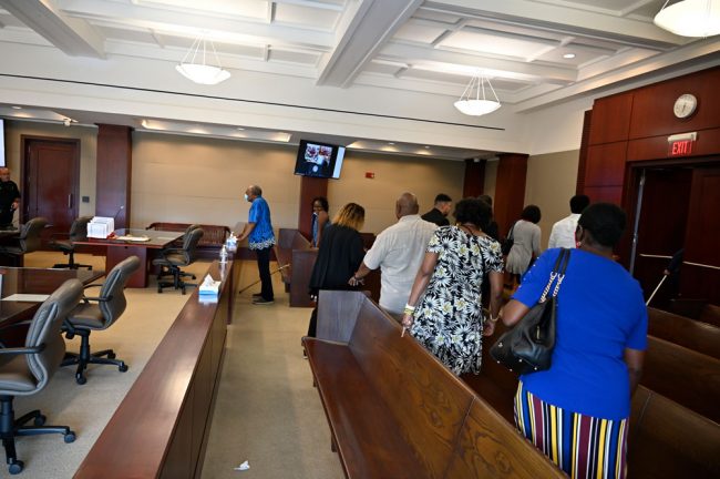 The victim's family filed out after the sentencing as Wiley's father and mother stood watching while he was being fingerprinted, before being taken away. (© FlaglerLive)