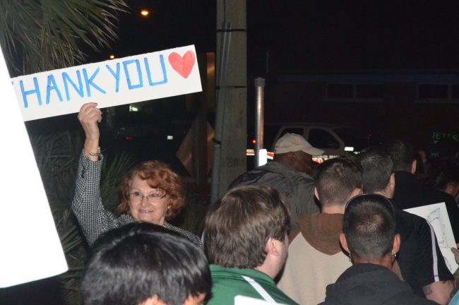 Viviane Lindeolsson held her own sign for the marchers at the foot of the bridge, when they reached beach-side. 'Those kids are doing better than we did in the 60s,' she said, recalling her own marches in Europe back then--in Belgium, specifically--'because they're more disciplined,  they're very articulate.' Click on the image for larger view. (© FlaglerLive)