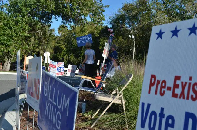Campaign volunteers amid a small forest of signs at the Palm Coast Community Center this afternoon. (© FlaglerLive)