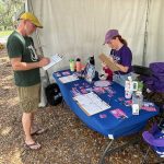 Roxanne Perret, an organizer with People Power for Florida, registers Mark Wendell to vote at a May festival in Orlando. Third-party voter registration groups have been threatened with fines and workers with jail time if they violate new state laws.