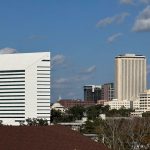 The Turlington Building, which houses the Florida Department of Education, stands in the foreground, with the Tallahassee skyline, including the Capitol building, beyond.