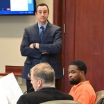 Brandon Washington in orange with his attorney Tim Pribisco, left, and Assistant State Attorney Jason Lewis during the hearing a year ago. Earlier this month, Washington was back in court, but representing himself. He again dueled with Lewis. (© FlaglerLive)