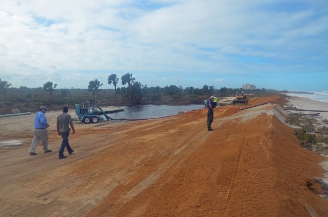 No dunes left, no coquina boulders, no dune vegetation, no walkway, no parking lot: Washington oaks Garden State Park's beach-side is a run, as state and county workers built an artificial barrier of packed sand and pumped water out of the parking lot to prevent another flood. 