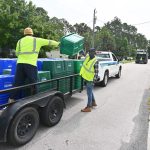 Waste Pro employees taking ownership of residents' recycling bins this week in Palm Coast. They did not pick up bins that did not have Waste pro's markings on them. (© FlaglerLive)