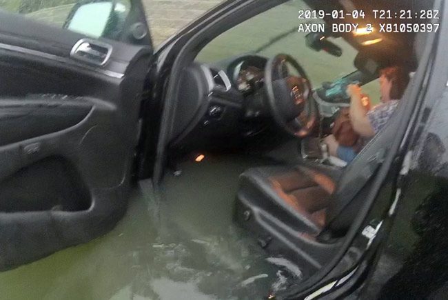 Lisa Burns, who is blind, in the car with her dog moments before two deputies helped her out of the car that her mother had driven into a pond. The image is taken from body camera footage. 