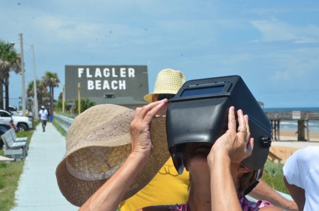 Linda Nugent, a 65-year-old Flagler Beach resident who was adamant that she'd not miss the eclipse--as she had opne in 1979--tried a welder's mask. Click on the image for larger view. (© FlaglerLive)