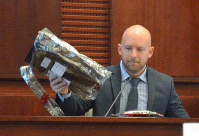 Former Florida Department of Law Enforcement Special Agent Clifford Whiteside, who testified for several hours today, with Paul Dykes's laptop, on which much of the incriminating evidence was found. Click on the image for larger view. (© FlaglerLive)