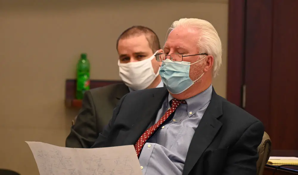 Defense attorney Garry Wood in the foreground with his client, Keith Johansen, as they went over the final list of jurors this afternoon. (© FlaglerLive)