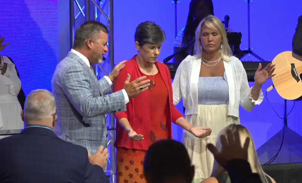 School Board member Jill Woolbright, flanked by New Way Church Pastor Richard Summerlin and his wife Kimberly Summerlin during a prayer-endorsement after Woolbright campaigned for seven minutes before the congregation during a service over the weekend. 