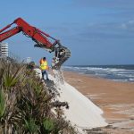Workers today building new dunes in a severely eroded section of shore along State Road A1A, south of the Flagler Beach city limit. (© FlaglerLive)