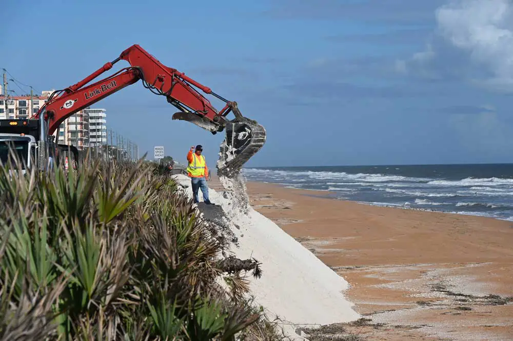 Workers today building new dunes in a severely eroded section of shore along State Road A1A, south of the Flagler Beach city limit. (© FlaglerLive)
