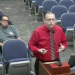 Brian Eichinger, manager of the county’s Office of Management and Budget, presenting to the County Commission at a workshop on Monday. Behind him, from right, Sheriff's Chief of Staff Mark Strobridge, Sheriff Rick Staly, and Commission candidate Raymond Royer. (© FlaglerLive via YouTube)