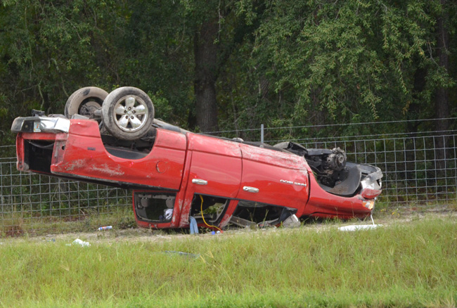 The Dodge Ram flipped and came to rest against a fence near Mile Marker 297 on I-95 this morning. (c FlaglerLive)