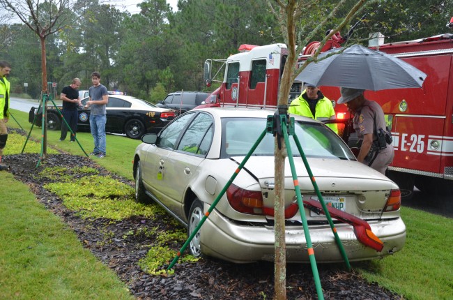 The Saturn. Christopher Maher, the driver of the Nissan, was at the scene, in the gray t-shirt, unhurt. Click on the image for larger view. (© FlaglerLive)